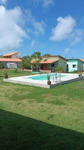 ein Swimmingpool mit zwei Stühlen und einem Haus in der Unterkunft Pousada Villa Esperança - Xandó - Caraíva BA in Caraíva
