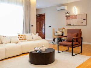 a living room with a couch and a table and a chair at Birch Hill Hotel Residence in Mama