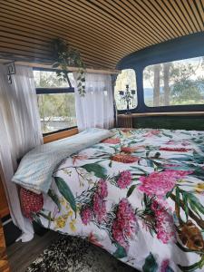 a bedroom with a bed with a floral comforter at Banksia Bus in Longley Lower