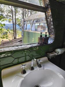 a bathroom sink with a window and a bus at Banksia Bus in Longley Lower +90 photos