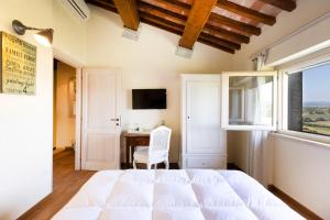 a bedroom with a bed and a desk and a window at CASALE DEI GELSOMINI 8, Emma Villas in Todi