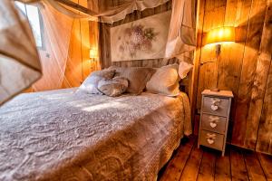 1 dormitorio con 1 cama en una habitación de madera en Glamping Tenuta Poggio Rosso, en Populonia