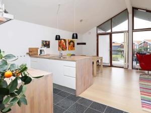 a kitchen with white cabinets and a wooden counter top at 4 star holiday home in Bogense in Bogense