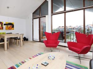 a living room with red chairs and a table at 4 person holiday home in Bogense-By Traum in Bogense +29 photos