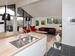 a kitchen with a sink and a living room at 4 star holiday home in Bogense in Bogense