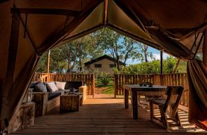 una grande tenda con tavolo e divano di Glamping Tenuta Poggio Rosso a Populonia