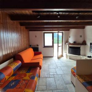 sala de estar con muebles de color naranja y chimenea en Accogliente Bilocale vicino Monte Pora - Presolana, en Malga Alta