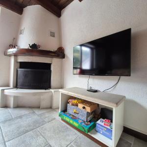 Una sala de estar con un televisor de pantalla plana en una pared. en Accogliente Bilocale vicino Monte Pora - Presolana, en Malga Alta