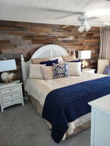 a bedroom with a bed with a wooden wall at Ashworh 1001 Four Bedroom Condo Oceanfront "Picture Perfect" in North Myrtle Beach +50 photos