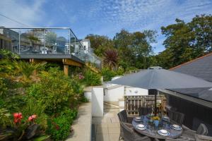a patio with an umbrella and a house at Valley View in Mevagissey
