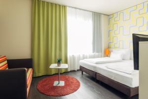 a bedroom with a bed and a window and a rug at harry's home Dornbirn hotel & apartments in Dornbirn