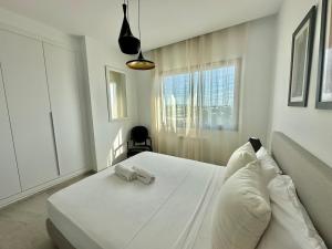 a bedroom with a white bed with a towel on it at Zenya apartment in La Marsa