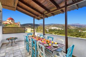 ein Tisch und Stühle auf einem Balkon mit Aussicht in der Unterkunft Villa Alexis House by Villa Plus in Kalo Chorio