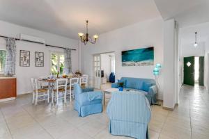 ein Wohnzimmer mit einem Tisch und blauen Stühlen in der Unterkunft Villa Alexis House by Villa Plus in Kalo Chorio