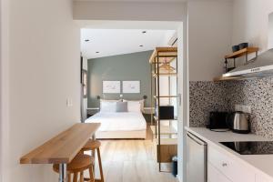 a bedroom with a bed and a kitchen with a table at Vagabond Guesthouse in Athens