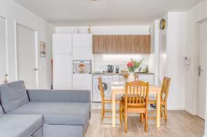 a living room with a couch and a table and chairs at Appartement agréable Parking inclus in Aubervilliers +16 photos