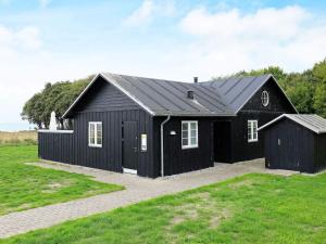 a black house with a black roof at 8 person holiday home in Nysted-By Traum in Nysted