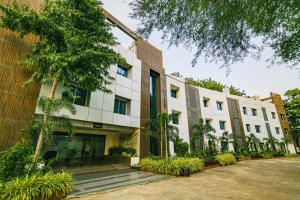 an external view of a building with trees and plants at Hotel Shri Ramkrishna Bagh Palace in Indore