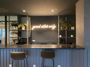 a kitchen with two stools and a sign that says good wish only at Ceylonz Suites by Stayla in Kuala Lumpur