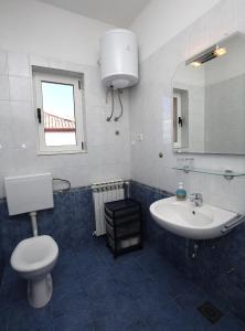 La salle de bains est pourvue d'un lavabo, de toilettes et d'un miroir. dans l'établissement Apartments Sara, à Kali