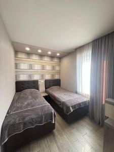 トビリシにあるapartment in Kojoriのベッド2台と窓のある寝室