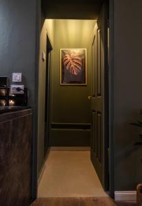 a hallway with green walls and a painting on the wall at Olive Central in Craiova +6 photos