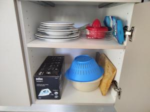 a cabinet with plates and bowls and a box in it at Anastasakos villas in Mavrovouni
