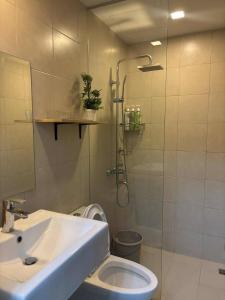 a bathroom with a shower and a sink and a toilet at Cozy 1-Bedroom Retreat in Iloilo City with City Views in Molo