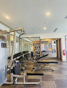 a gym with a row of treadmills and machines at Cozy 1-Bedroom Retreat in Iloilo City with City Views in Molo