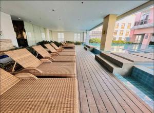 a row of chairs and a pool in a building at Cozy 1-Bedroom Retreat in Iloilo City with City Views in Molo