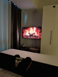 a bedroom with a bed with a tv on the wall at Stunning 42nd Floor Apt with Netflix in Manila