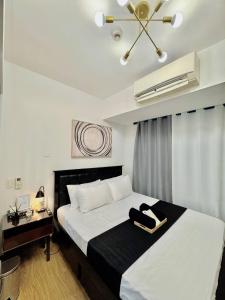 a bedroom with a bed with a black and white comforter at Stunning 42nd Floor Apt with Netflix in Manila