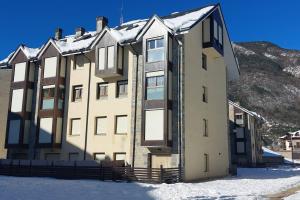 a large building with snow on top of it at Apartamento Alma centro Biescas l WIFI l Parking in Biescas