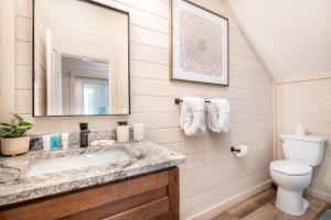 a bathroom with a sink and a toilet and a mirror at Tranquility Awaits By Avada Properties in Sandy Ridge +41 photos