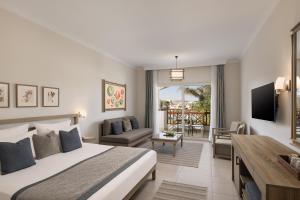 a bedroom with a bed and a living room at Iberotel Casa Del Mar Resort in Hurghada