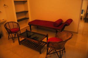 a living room with a red couch and chairs at Palm View Residency in Varkala