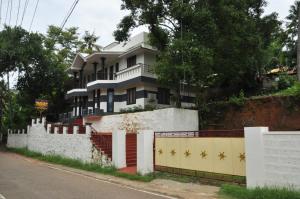 a house on the side of a hill with a fence at Palm View Residency in Varkala
