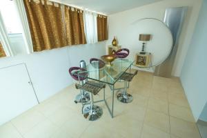 ポンタ・デルガダにあるFlor do Mar Houseの鏡付きの部屋(ガラスのテーブルと椅子付)