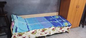 a small bed with a blue comforter on it at Арт-Хостел PIONER 2 in Sumy