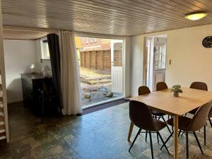 a dining room with a table and chairs and a window at Kaj Munks Gade 19 - 3 værelses - 98m2 in Maribo