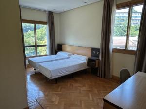 a hotel room with two beds and two windows at Hotel Eibar in Éibar +38 photos