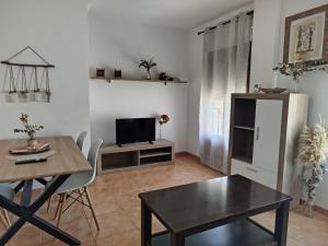 Una sala de estar con una mesa de comedor y un televisor. en La Encantada, en Huéscar