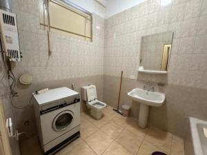 a bathroom with a washing machine and a sink at Prime location 2 bed rooms Apartment , near the Nile & Cairo Center in Cairo +19 photos