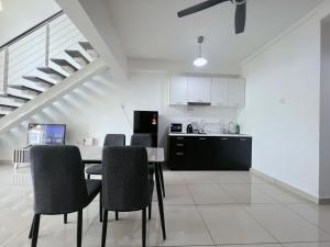 a kitchen and dining room with a table and chairs at The Nest Living Stay in Gua Sai