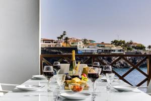 a table with glasses of wine and food on it at Le Cécilia in Puerto de Santiago