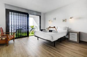 a bedroom with a large bed and a large window at Le Cécilia in Puerto de Santiago