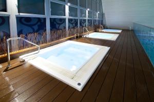 a bathroom with two hot tubs on a wooden deck at Eden Resort & Spa in Mielno