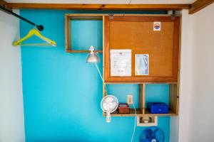 ein Raum mit einer blauen Wand mit einem Ventilator und einem Schrank in der Unterkunft Crash Pad Adventure Hostel in Hopkins
