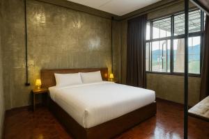 a bedroom with a bed and a large window at Lanna Loft Hostel in Chiang Mai