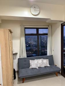 a living room with a blue couch in front of a window at Heart of Cebu Cozy Studio with Pool, Gym, Wifi and Netflix near Cebu City,Ayala and IT Park in Cebu City